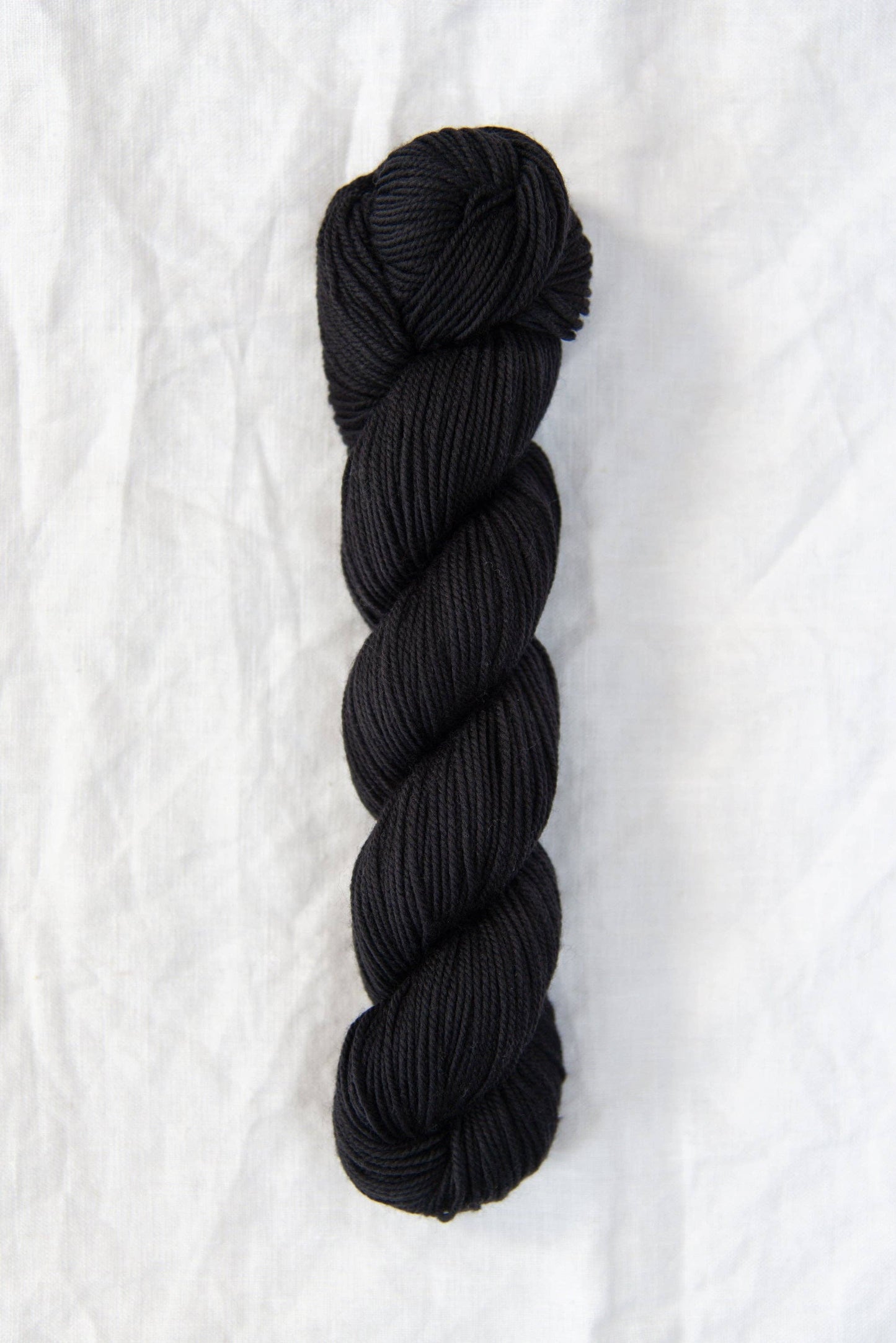 Black skein of Chickadee DK weight 100% American wool yarn.