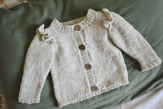 Cute baby cardigan knitting pattern with ruffles designed by Katerina Rieckel.