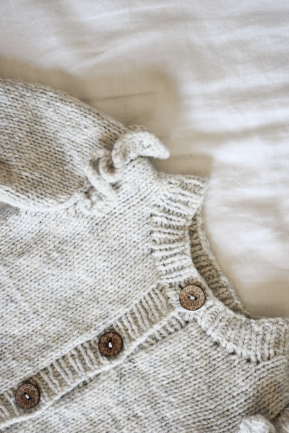 Close-up of the Ruffle Baby Cardigan knitting pattern by Katerina Rieckel from Nest Creative Works.