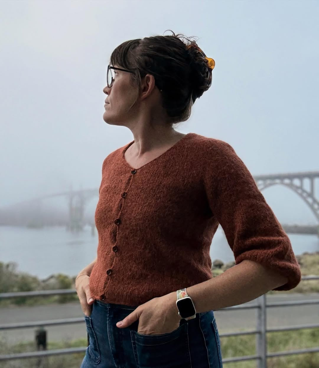 Woman wearing a brown knitted cardigan with a blurred background