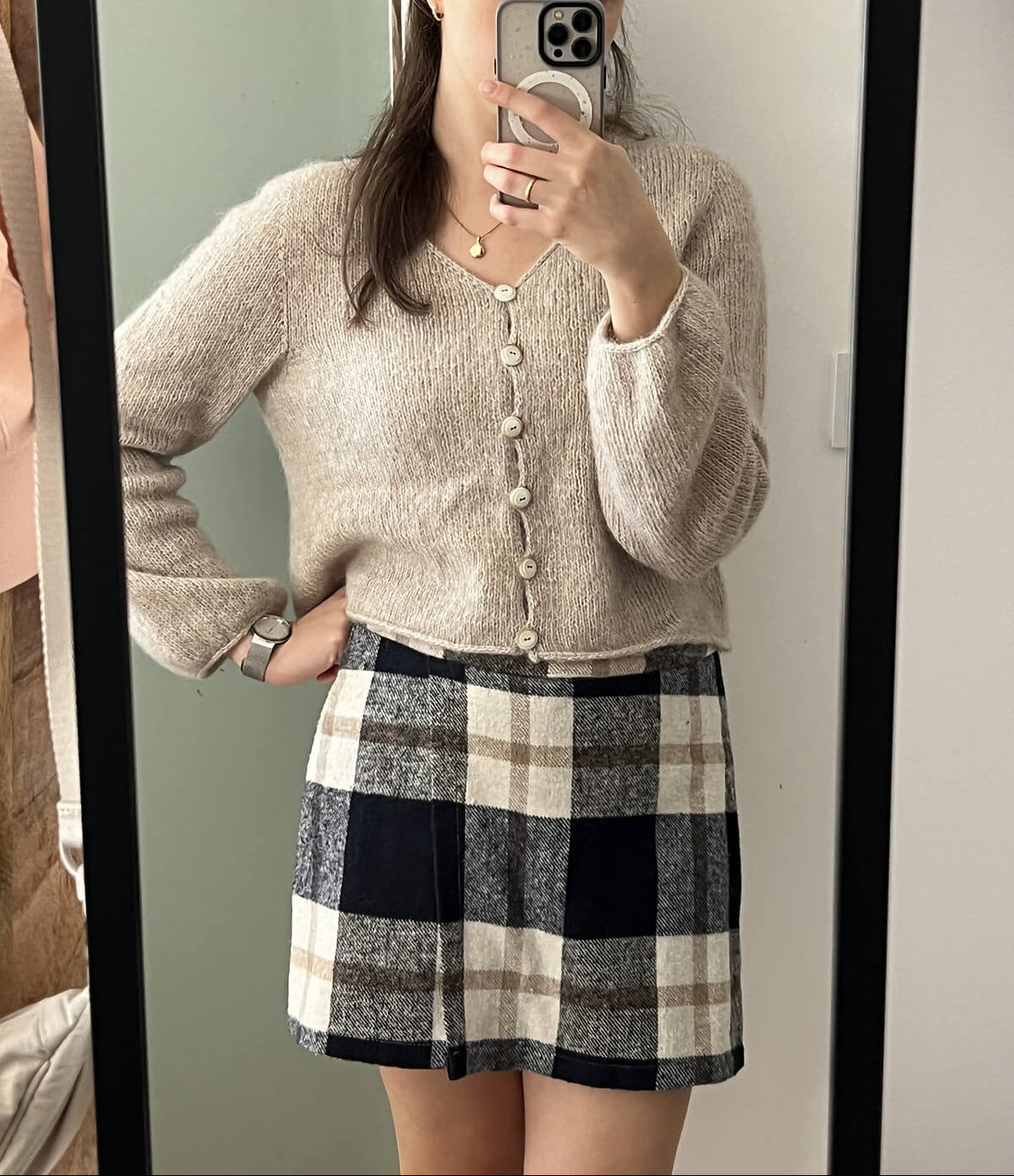 Cloud Cardigan pattern in beige color paired with a plaid skirt.