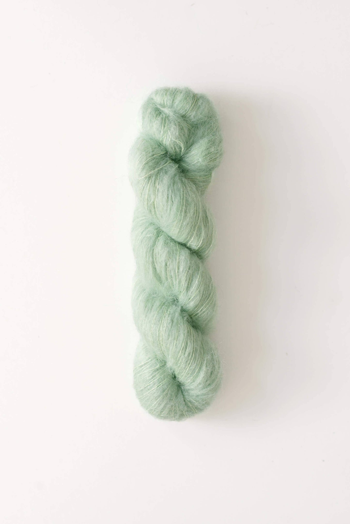 Mint green skein of Dove mohair silk yarn.