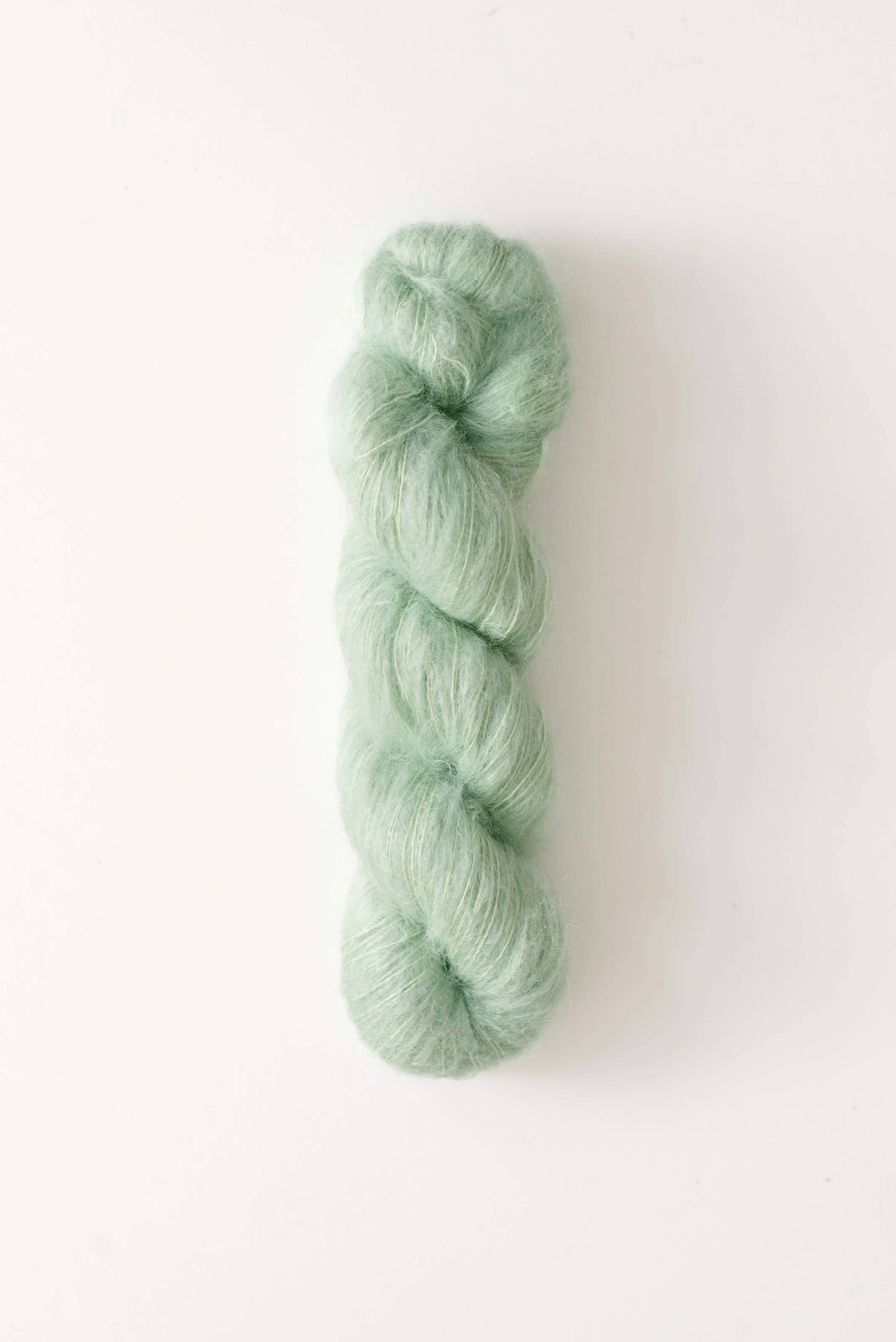 Mint green skein of Dove mohair silk yarn.