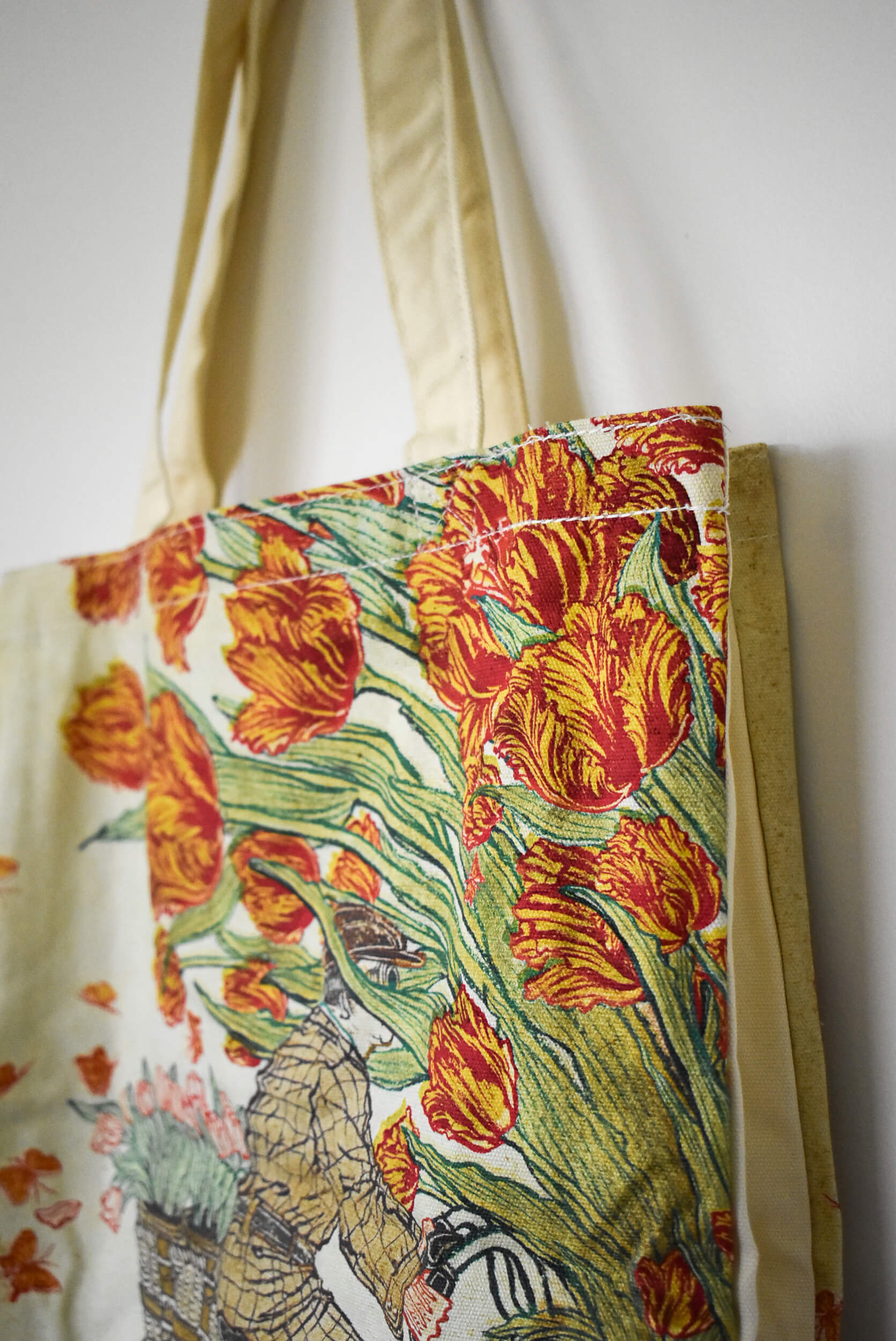 Floral tote bag with red tulips on a white background.