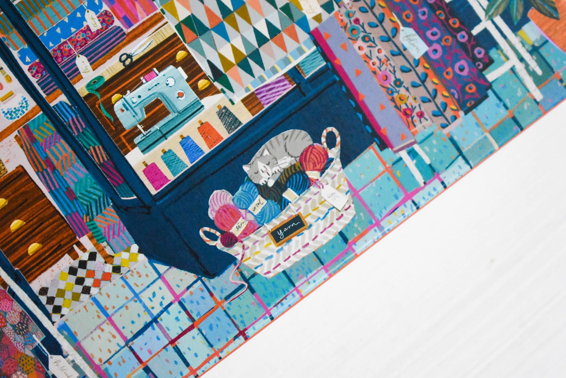 Cat sleeping on yarn balls puzzle detail.