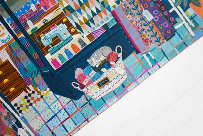 Cat sleeping on yarn balls puzzle detail.