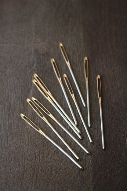 Large eye metal darning needle.