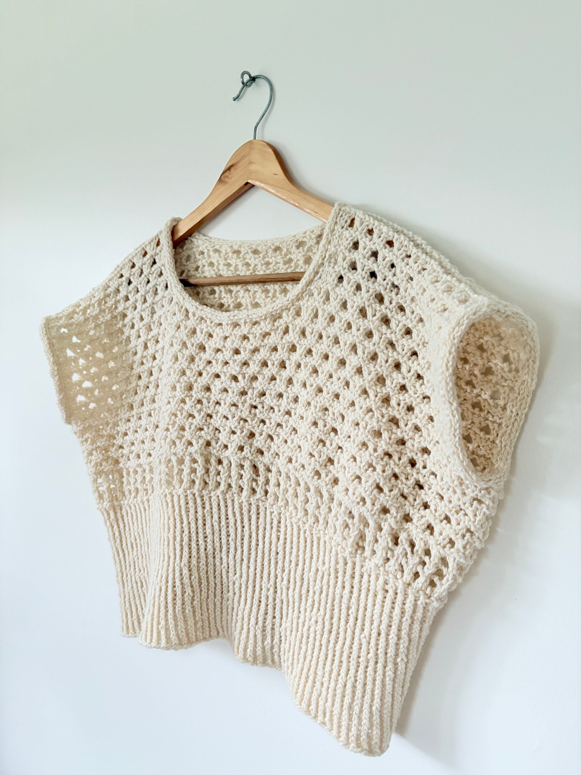 Beige knitted vest resembling crochet.
