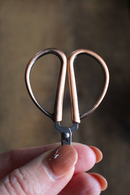 Small garden-style scissors for cutting yarn.