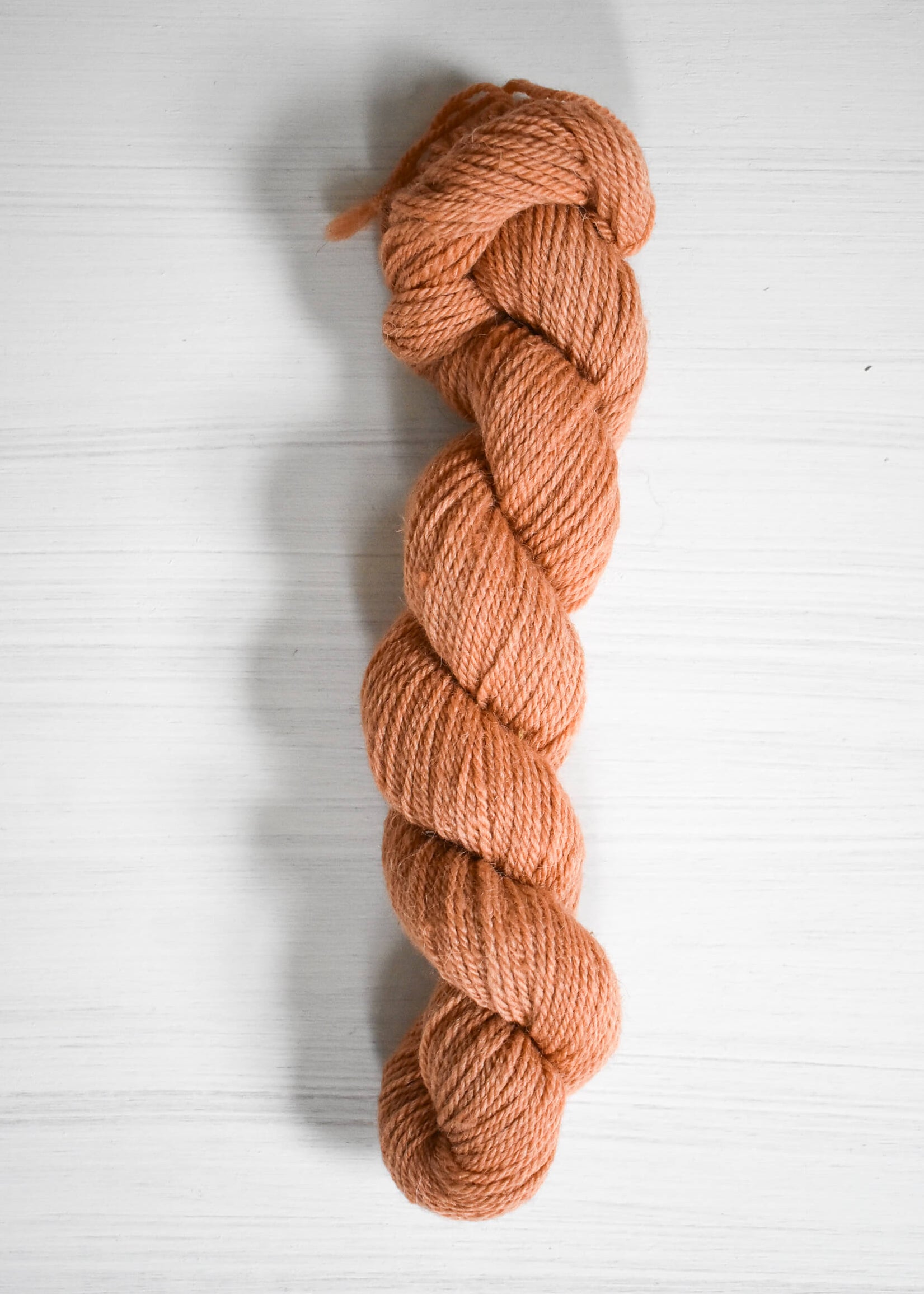 Peach-colored baby alpaca wool yarn skein.