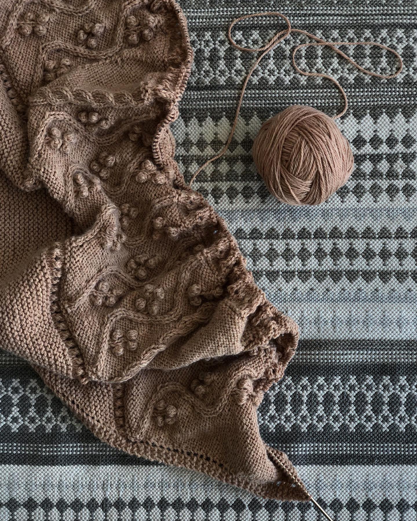 Image of the shawl knitting pattern worked in beige color, in Oysters and Purls yarn.