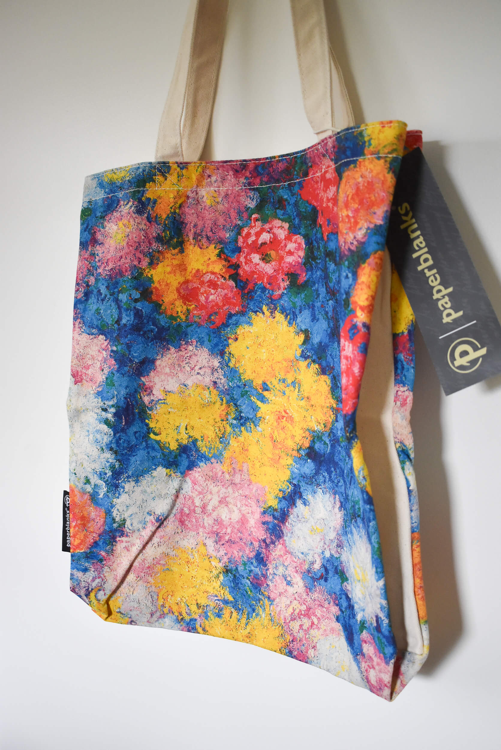 Floral tote bag with a visible brand tag.