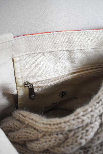 Knitting bag with a zippered pocket.