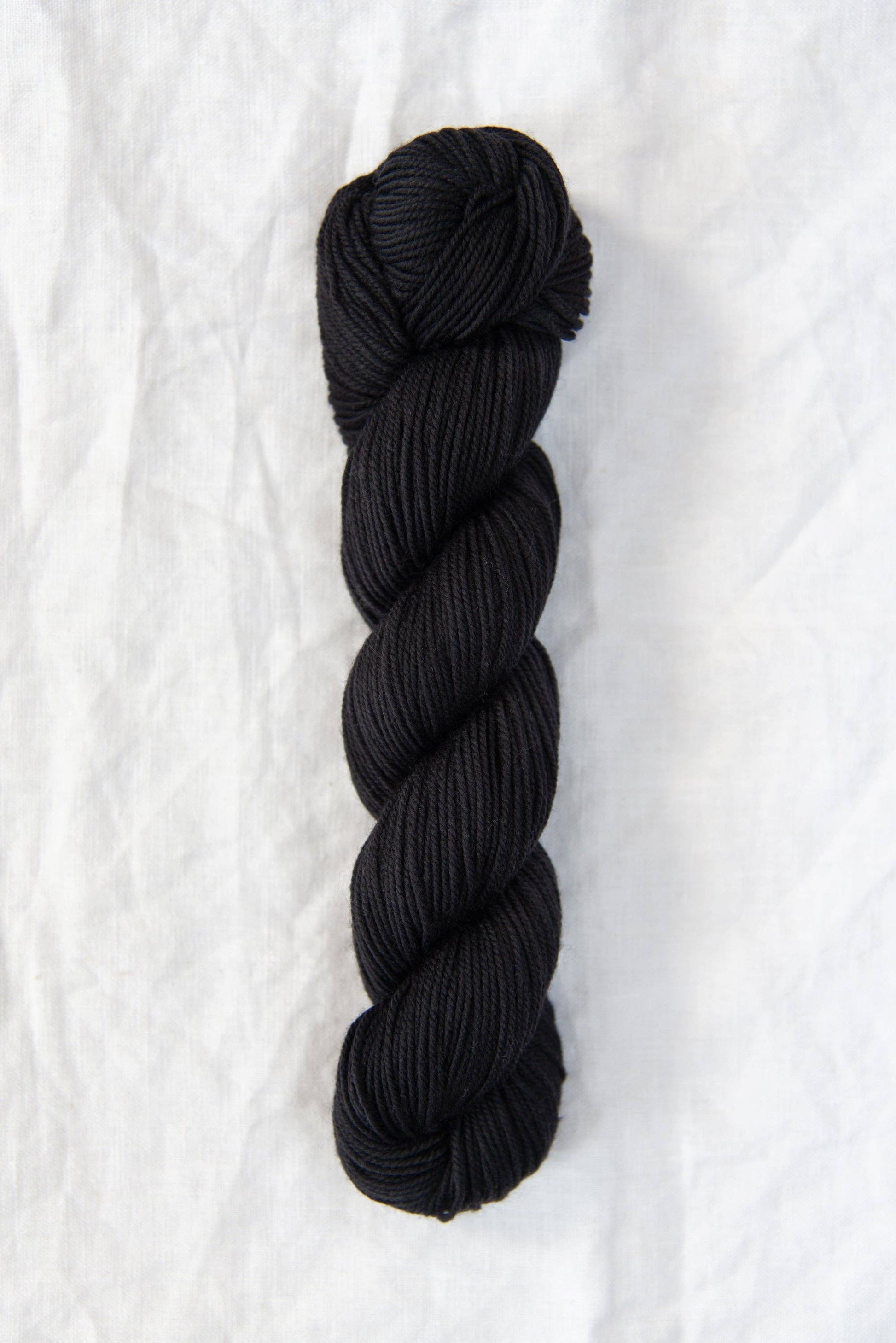 Black skein of Chickadee DK weight 100% American wool yarn.