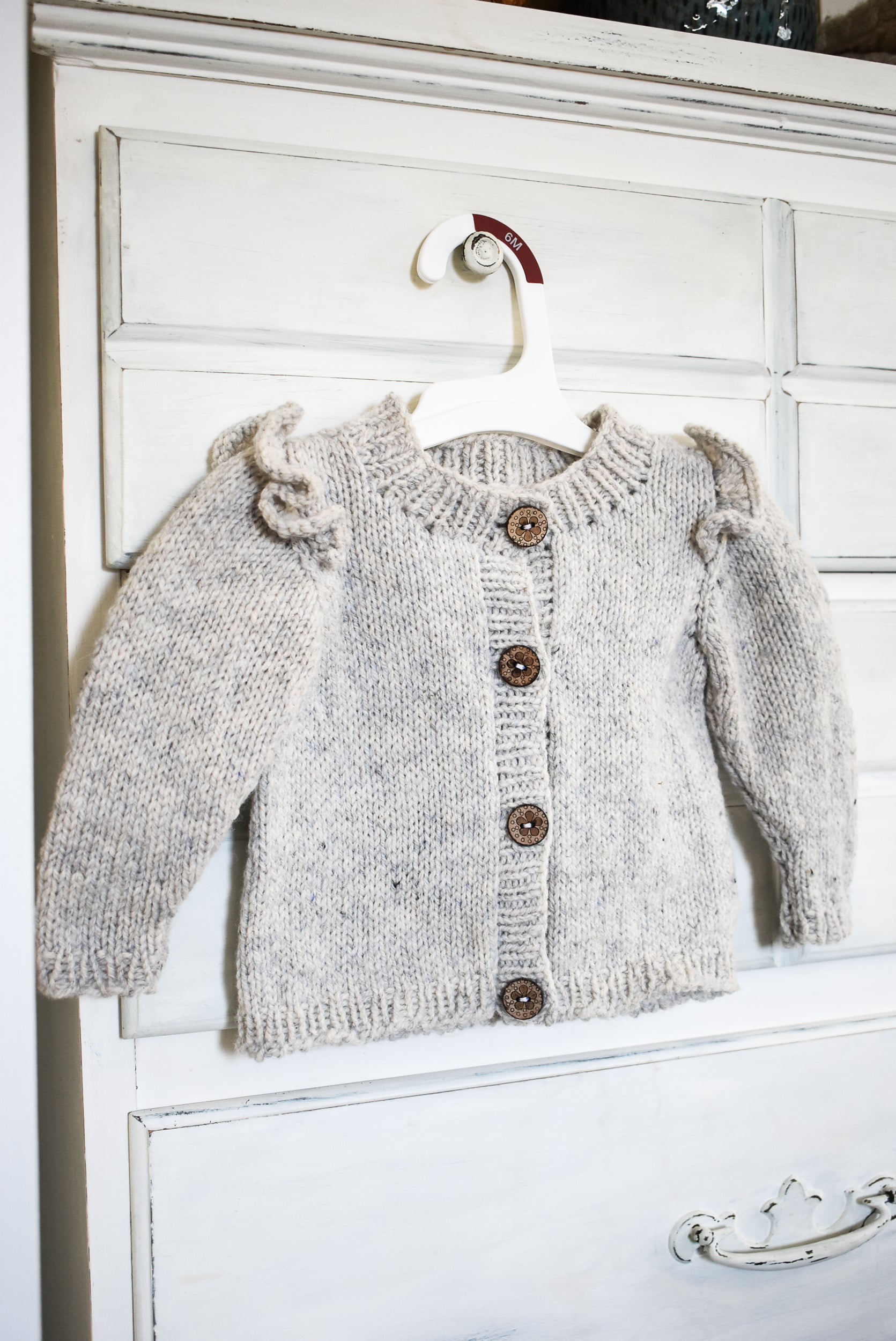 Ruffle baby cardigan knitting pattern for babies and toddlers.