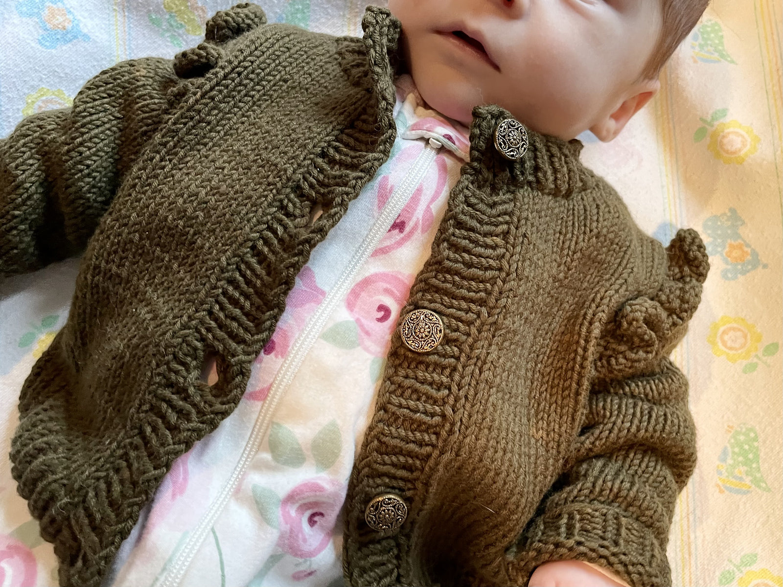 Ruffle baby cardigan knitted in green color.