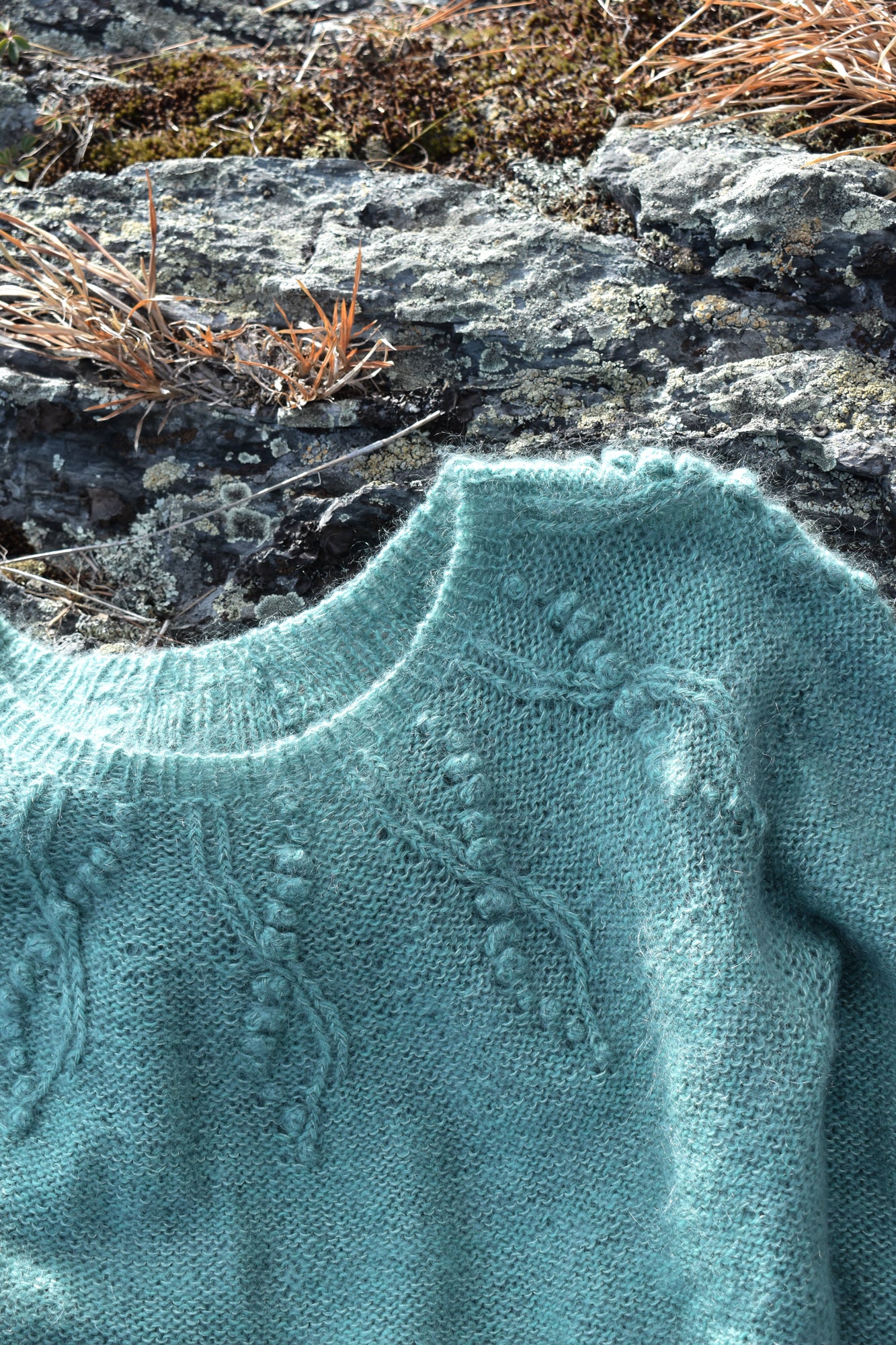 Detail of the bobbles and lace pattern on the yoke sweater knitting pattern.