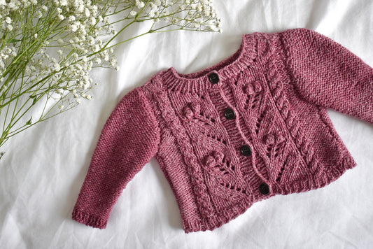 Image showing Sofie's Cardigan Baby Knitting pattern project laid flat on a white sheet.