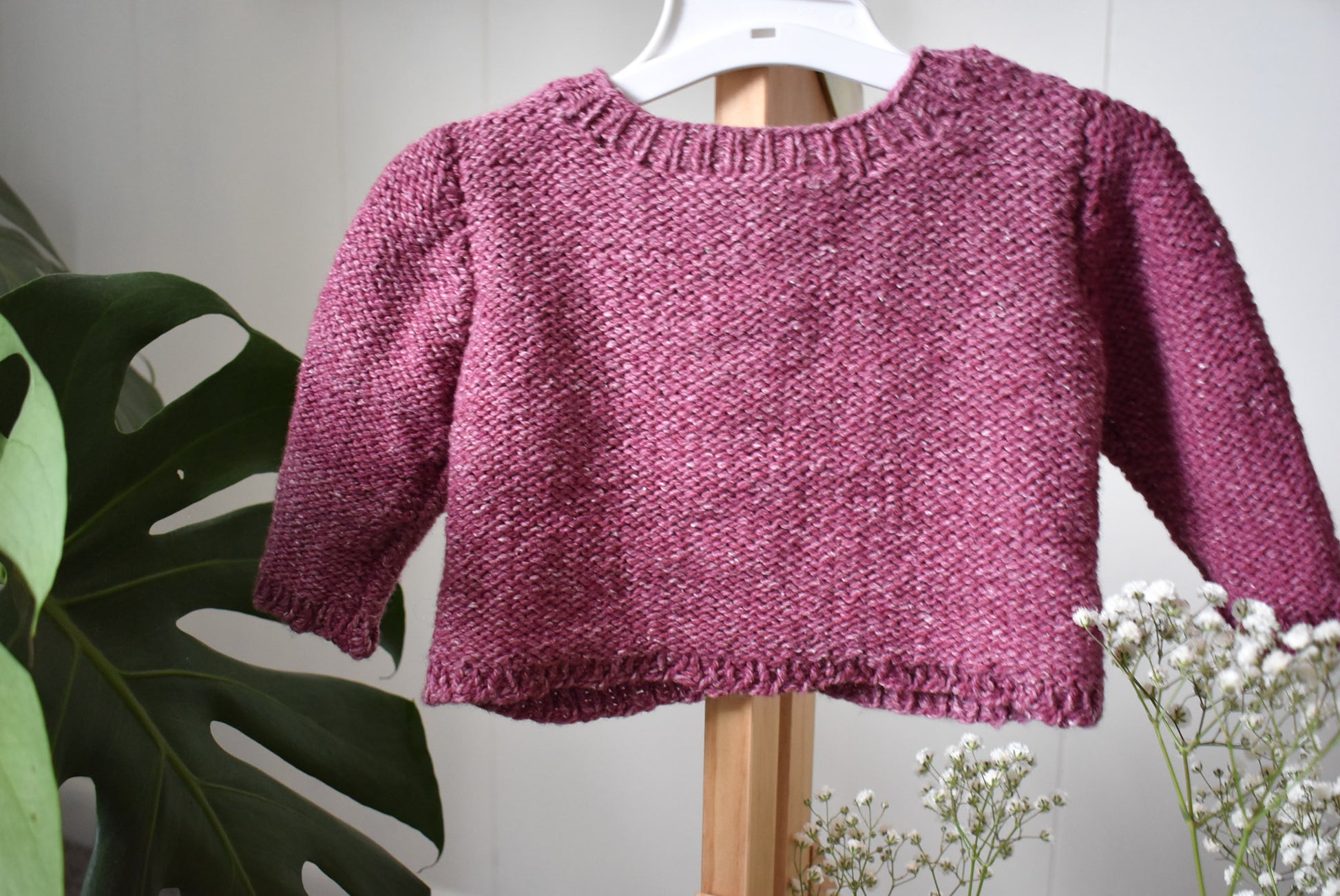 Photo of the back of a pink hand-knit sweater based on Sofie's Cardigan knitting pattern.