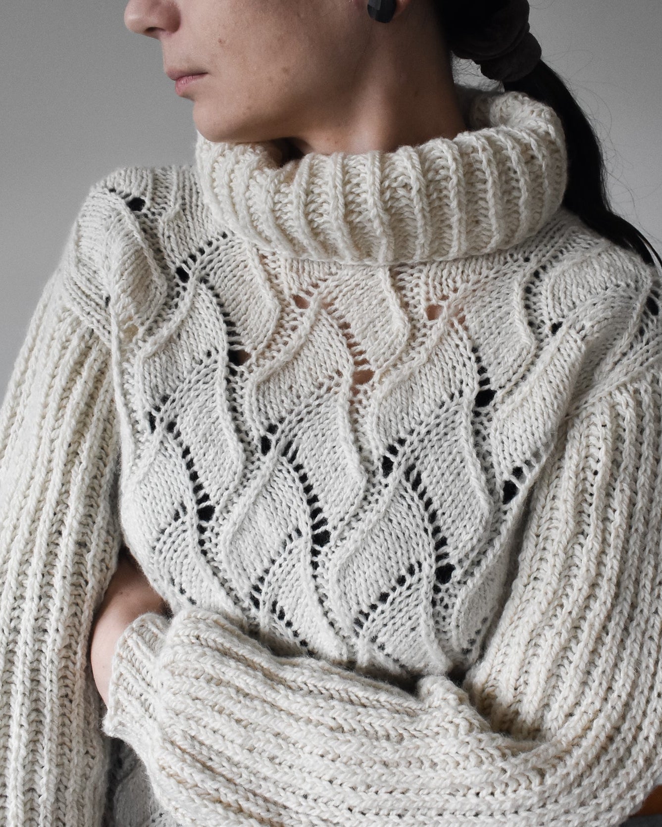 Cream-colored knit sweater with a textured pattern.
