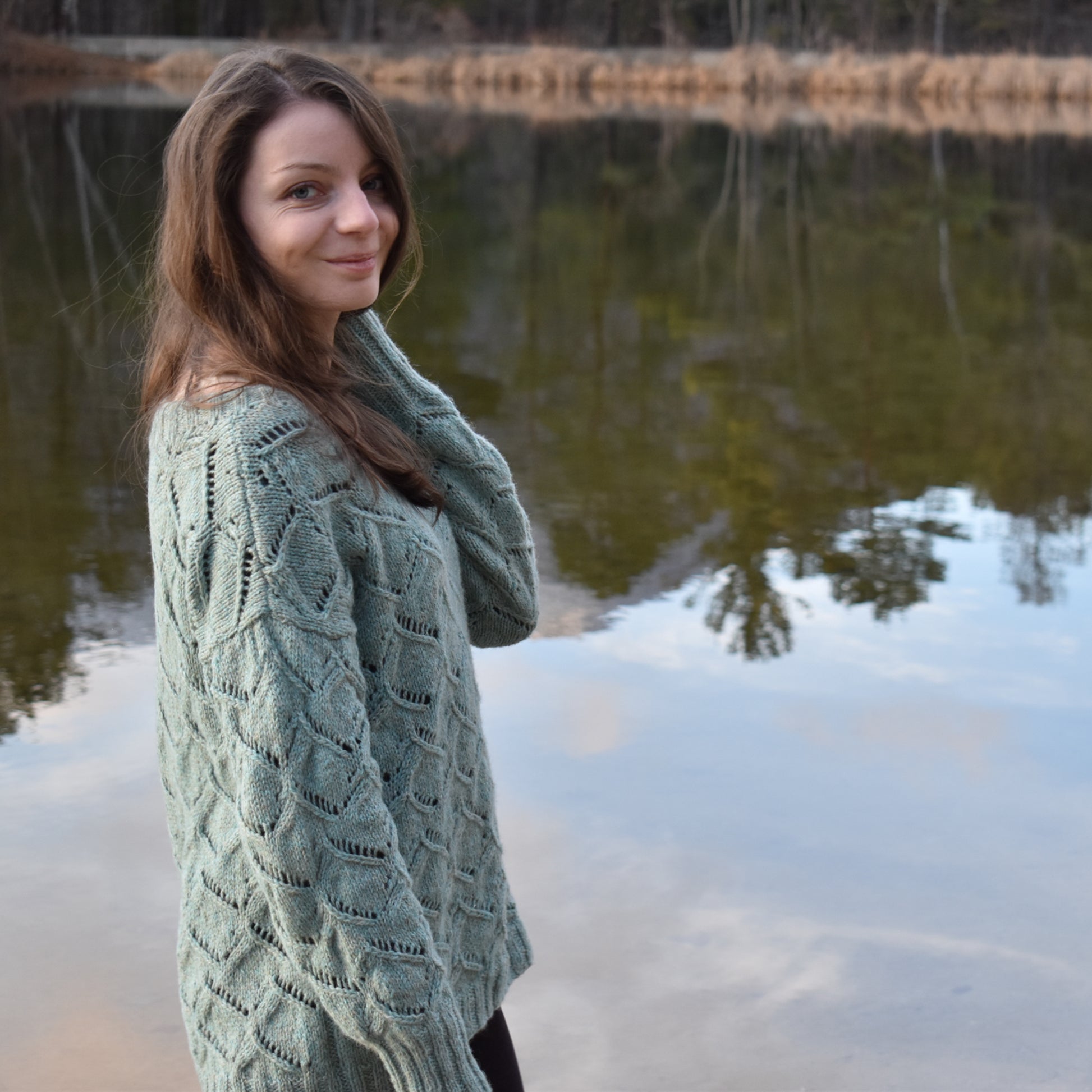 Woman wearing the finished project of a textured sweater knitting pattern.