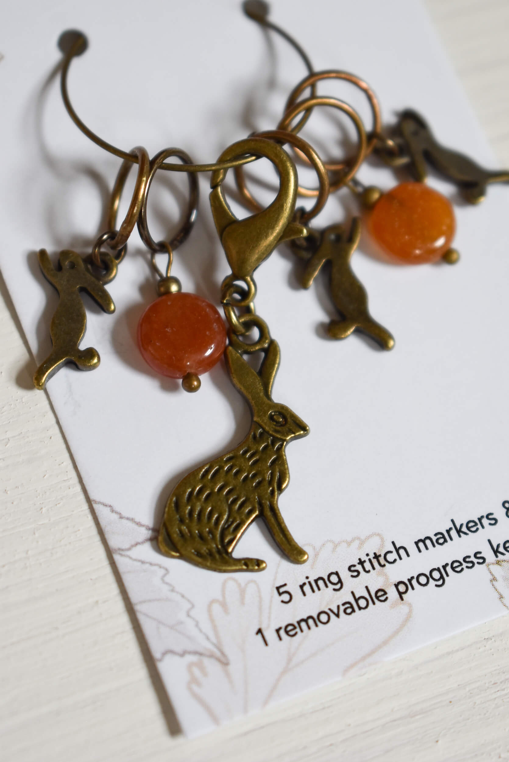 Bronze bunny stitch markers with orange beads.