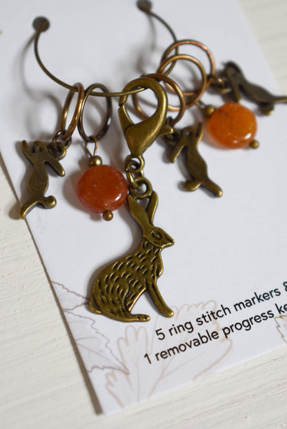 Bronze bunny stitch markers with orange beads.